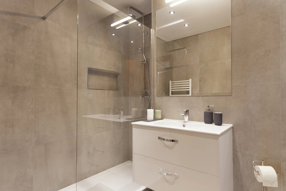 Photo d'un artisan plombier-chauffagiste en tenue professionnelle, travaillant sur l'installation d'une pompe à chaleur ou d'un système de climatisation complexe dans un chantier de bâti ancien ou avec contraintes architecturales visibles. L'artisan est concentré sur son travail technique, manipulant des tuyauteries ou des composants du système. La scène doit transmettre la maîtrise technique, l'expertise et la capacité à intervenir sur des installations exigeantes.